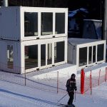 Container con vetrate su pista da sci – Struttura in container bianchi con ampie vetrate, utilizzata come area operativa per eventi sportivi invernali.
