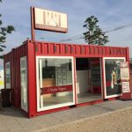 Container ristorazione trasformato in punto vendita per piadine, con struttura rossa, vetrate e insegna personalizzata.