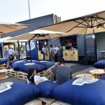 Locale bar realizzato in container, con sportello di servizio e area clienti all'aperto, ideale per eventi e fiere.