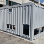 Container data center grigio con finestre di ventilazione, realizzato per ospitare sistemi IT e garantire un ambiente stabile e protetto.