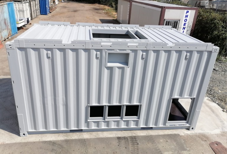 Container data center modulare grigio con aperture per ventilazione e raffreddamento, progettato per proteggere infrastrutture IT e garantire un ambiente sicuro e stabile.