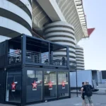 Container showbox Virgin Radio a due livelli con vetrate e terrazza, posizionato all’esterno dello stadio di San Siro a Milano, utilizzato come studio radiofonico per eventi live.