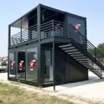 Struttura modulare Virgin Radio a due livelli con scala laterale in acciaio, pareti vetrate e branding frontale, installata in un prato adibito a spazio per concerti.