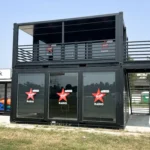 Struttura containerizzata Virgin Radio a due piani con terrazza panoramica e ampie vetrate al piano terra, collocata in area eventi e personalizzata con loghi Virgin Radio Style Rock.