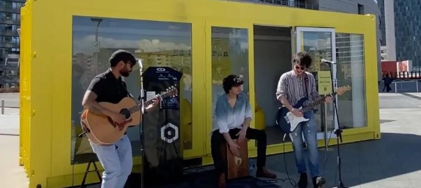 Container palco giallo Open Stage, utilizzato per una performance live con band musicale, in uno spazio urbano all’aperto.