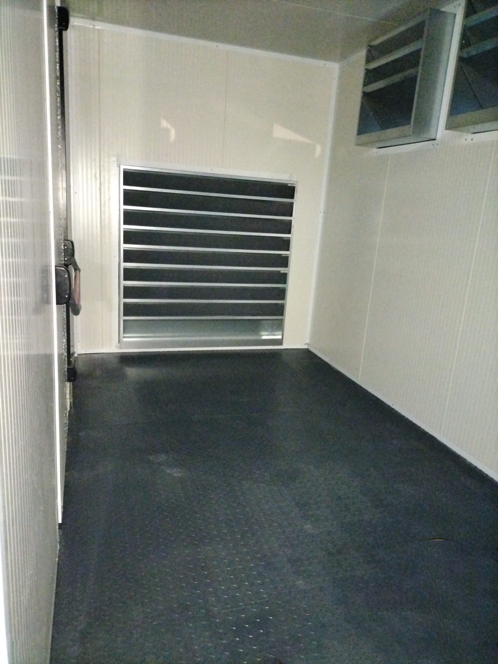 Spazio interno di un container coibentato con pavimento antiscivolo e prese d'aria, progettato per conservazione di merci sensibili o ambienti refrigerati.