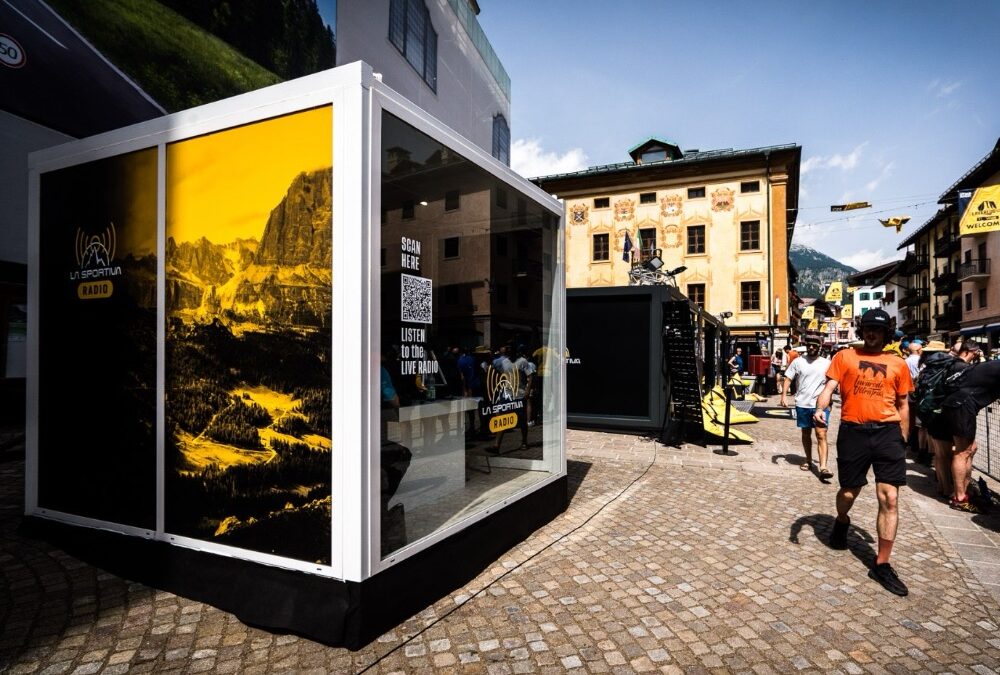 Showbox da 10’ personalizzato per La Sportiva Radio durante La Sportiva Lavaredo Ultra Trail 2024, posizionato in una piazza storica con struttura moderna e grafiche montane.