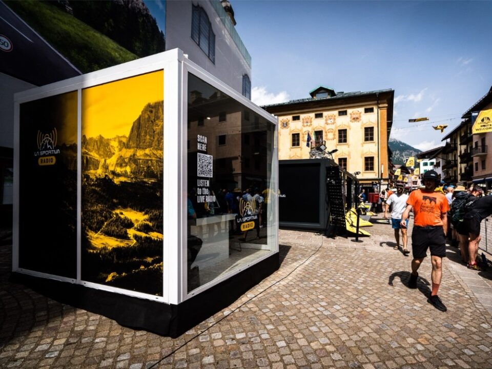 Showbox da 10’ personalizzato per La Sportiva Radio durante La Sportiva Lavaredo Ultra Trail 2024, posizionato in una piazza storica con struttura moderna e grafiche montane.