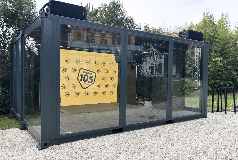 Studio Radio 105 per Sanremo 2025 in un container vetrato, con arredamento moderno e area dedicata a interviste e dirette radio.