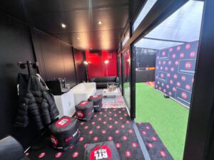 Interno dello studio RTL 102.5 con arredamento moderno, poltrone personalizzate e area hospitality per gli ospiti del festival di Sanremo 2025.