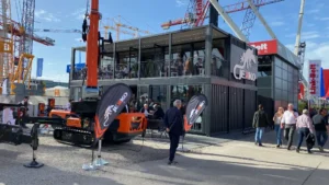 Stand espositivo Jekko a Bauma 2025 con struttura modulare su due livelli realizzata da Phoenix International e macchinari da costruzione in mostra sul piazzale.