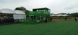 Visuale laterale della struttura containerizzata Garnier Fructis con terrazza e spazi allestiti, nel contesto open-air del Nameless Festival.