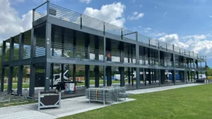 Fase di installazione della struttura containerizzata su due livelli progettata da Phoenix International per il Nameless Festival 2025, con piattaforme in ferro e moduli prefabbricati.
