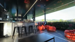 Interno di un modulo VIP containerizzato al Nameless Festival 2025, con area lounge arredata, sedute personalizzate Red Bull e vista panoramica sul paesaggio.