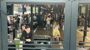 Interno affollato della VIP Lounge containerizzata realizzata da Phoenix International per il Nameless Festival 2025, con pubblico, bar e area relax.
