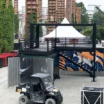 Struttura container a due livelli in fase di montaggio con scala laterale e grafiche street art, realizzata da Phoenix International per Jägermeister al Kappa FuturFestival.
