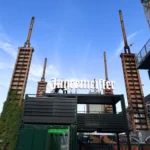 Vista frontale della struttura container Jägermeister con terrazza e insegna LED progettata da Phoenix International per evento al Kappa FuturFestival.