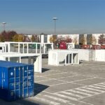 Container bianchi e blu collocati nel piazzale esterno di EICMA 2025, disposti in configurazione modulare per la futura area Your Urban Mobility.