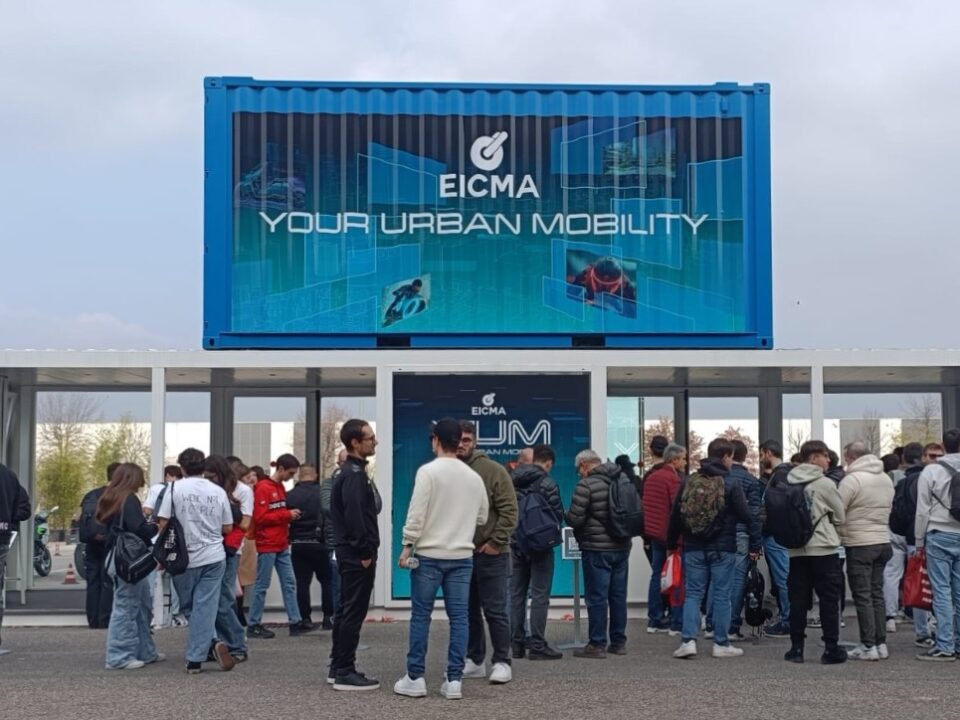 Container espositivo brandizzato EICMA Your Urban Mobility posizionato all’ingresso dell’area Y.U.M., con numerosi visitatori in attesa davanti alla struttura durante l’edizione 2025.