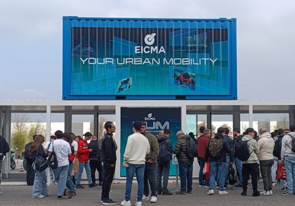 Container espositivo brandizzato EICMA Your Urban Mobility posizionato all’ingresso dell’area Y.U.M., con numerosi visitatori in attesa davanti alla struttura durante l’edizione 2025.