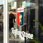 Ingresso container vetrato con logo Rolling Stone e Genoa durante evento al Festival di Sanremo