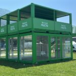 Struttura espositiva Garnier Fructis composta da container modulari verdi con ampie vetrate e terrazze panoramiche.