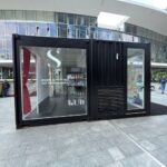 Vista laterale del container espositivo Alfaparf con prodotti Semi di Lino e ingresso vetrato.