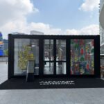Vista frontale del pop-up store Alfaparf Milano Professional realizzato con container modulari vetrati.